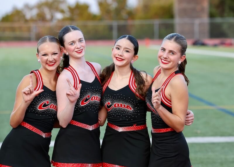 Four Cavalette teammates posing together on the football field